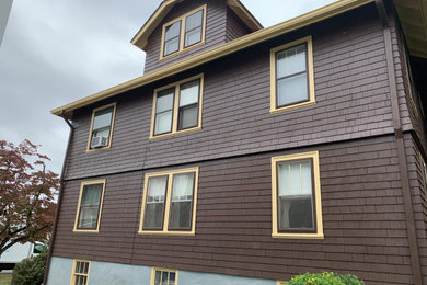 Inspiration for a large timeless brown three-story wood exterior home remodel in Providence with a shingle roof