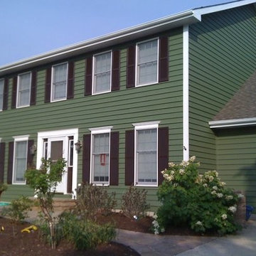 Exterior Painting - Green two story traditional home with white trim.