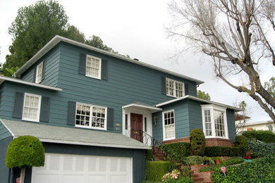 Modelo de fachada azul grande de tres plantas con revestimiento de madera