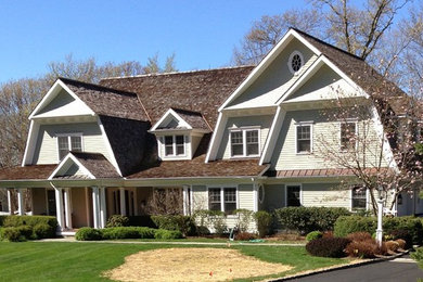 Large traditional beige two-story wood house exterior idea in New York with a gambrel roof and a shingle roof