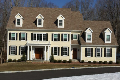 Mid-sized traditional beige two-story vinyl exterior home idea in New York with a shingle roof