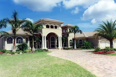 Example of a large beige two-story exterior home design in Miami