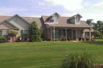 Example of a large country two-story brick house exterior design in Oklahoma City