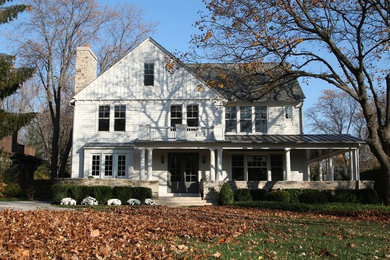 Diseño de fachada blanca campestre de tamaño medio de dos plantas con revestimiento de madera y tejado a dos aguas