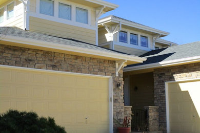 Example of a large transitional yellow two-story mixed siding house exterior design in Denver with a clipped gable roof and a shingle roof