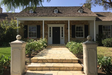 Inspiration for a mid-sized timeless beige one-story stone gable roof remodel in Los Angeles
