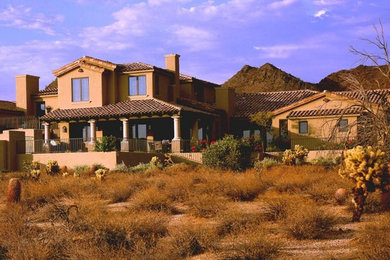 Cette image montre une façade de maison beige sud-ouest américain en adobe à un étage.