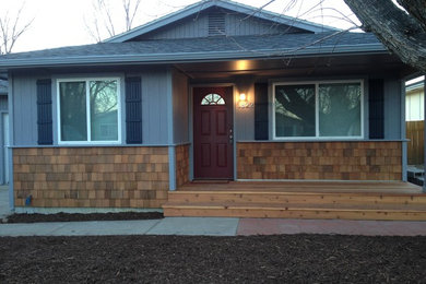 Ejemplo de fachada de casa gris de estilo americano pequeña de una planta con revestimiento de madera y tejado de teja de madera