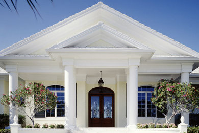Large tuscan white one-story stucco exterior home photo in Dallas with a clipped gable roof