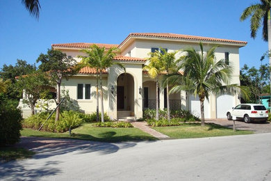 Großes, Zweistöckiges Mediterranes Einfamilienhaus mit Putzfassade, gelber Fassadenfarbe, Walmdach und Ziegeldach in Miami