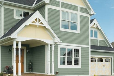 Cette image montre une grande façade de maison verte à un étage.