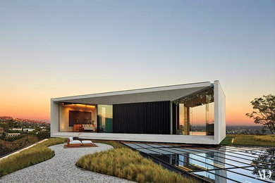 Идея дизайна: большой, двухэтажный, белый частный загородный дом в современном стиле с облицовкой из цементной штукатурки и плоской крышей
