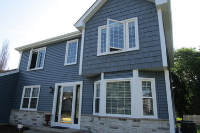 Foto de fachada de casa azul clásica de tamaño medio de dos plantas con revestimiento de vinilo y tejado a dos aguas