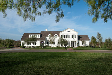 Exemple d'une façade de maison blanche chic de taille moyenne et à un étage avec un revêtement en vinyle et un toit à deux pans.