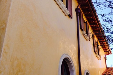 Foto della facciata di una casa gialla mediterranea a due piani