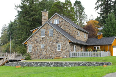 Mid-sized elegant brown three-story stone gable roof photo in Seattle