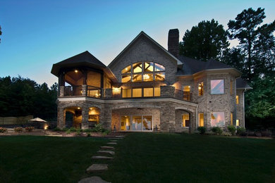 Inspiration for a large timeless beige two-story stone gable roof remodel in Charlotte