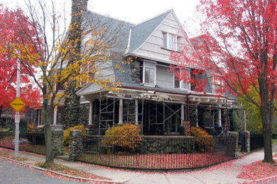 Foto de fachada de casa gris de estilo americano de dos plantas con revestimientos combinados, tejado a dos aguas y tejado de teja de madera