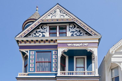 Immagine della facciata di una casa grande multicolore vittoriana a tre piani con rivestimento in legno e tetto a capanna