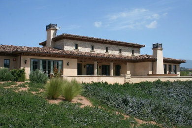 Large mediterranean beige two-story mixed siding house exterior idea in San Diego with a hip roof and a tile roof