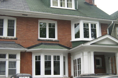 Design ideas for a brick house exterior in Toronto with three floors.