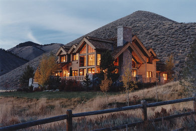 Inspiration for a huge rustic brown two-story wood exterior home remodel in Other