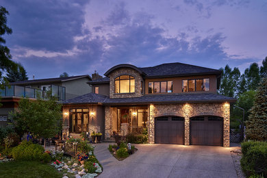Large elegant brown two-story stone exterior home photo in Calgary with a gambrel roof