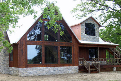 Foto de fachada marrón rústica de tamaño medio de dos plantas con revestimientos combinados y tejado a dos aguas