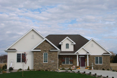 Aménagement d'une façade de maison beige classique de taille moyenne et de plain-pied avec un revêtement mixte et un toit à quatre pans.