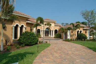 Example of a large classic beige one-story stucco house exterior design in Orlando with a hip roof and a tile roof