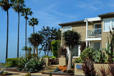 Ispirazione per la facciata di una casa beige tropicale a due piani di medie dimensioni con rivestimento in legno