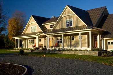 Diseño de fachada beige tradicional grande con revestimientos combinados y tejado a dos aguas