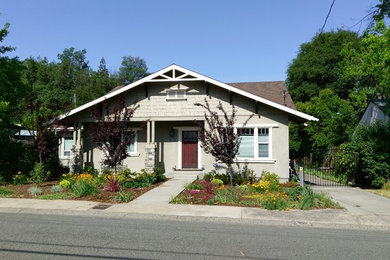 Diseño de fachada de casa gris de estilo americano de tamaño medio de una planta con revestimiento de madera, tejado a cuatro aguas y tejado de metal