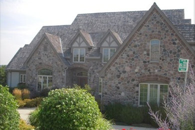 Example of a brown two-story stone exterior home design in Milwaukee