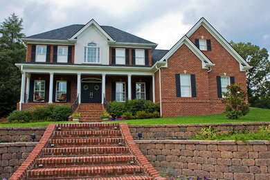 Inspiration for a large red two-story brick exterior home remodel in Other