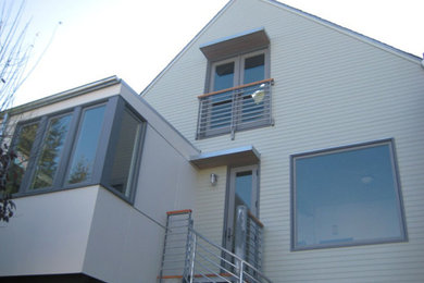 Modelo de fachada de casa gris clásica grande de tres plantas con revestimiento de madera y tejado a dos aguas