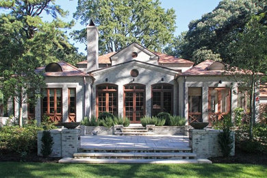 Inspiration for a mid-sized timeless gray one-story brick house exterior remodel in Other with a hip roof and a tile roof