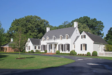 Aménagement d'une grande façade de maison blanche classique à un étage avec un revêtement en vinyle, un toit à deux pans et un toit en shingle.