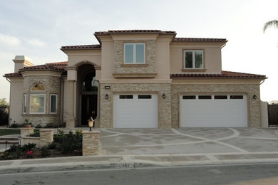 Inspiration for a large timeless beige two-story mixed siding exterior home remodel in Orange County with a hip roof