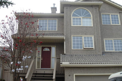 他の地域にある低価格の中くらいなトランジショナルスタイルのおしゃれな家の外観 (漆喰サイディング) の写真