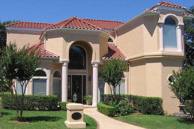 Ejemplo de fachada beige de estilo americano grande de dos plantas con revestimiento de estuco y tejado a cuatro aguas