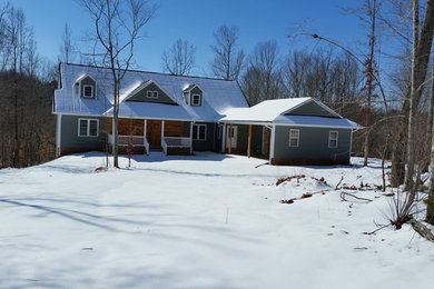Ejemplo de fachada verde de estilo de casa de campo de tamaño medio de dos plantas con revestimiento de madera
