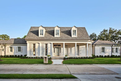 Diseño de fachada de casa blanca clásica renovada grande de una planta con revestimiento de estuco, tejado a dos aguas y tejado de teja de madera