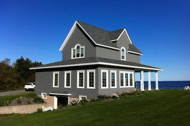 Ejemplo de fachada gris marinera de tamaño medio de dos plantas con revestimiento de madera y tejado a dos aguas
