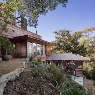 Inspiration for a midcentury three-storey brown house exterior in Los Angeles with wood siding.