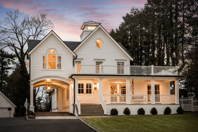 Diseño de fachada de casa blanca actual grande de tres plantas con revestimiento de madera, tejado a dos aguas y tejado de varios materiales