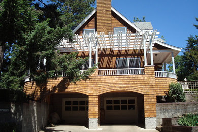 Imagen de fachada tradicional grande de tres plantas con revestimiento de madera y tejado a dos aguas