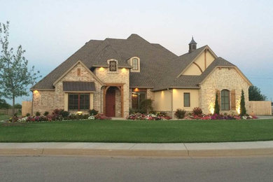 Inspiration for a timeless beige two-story mixed siding exterior home remodel in Oklahoma City with a shingle roof