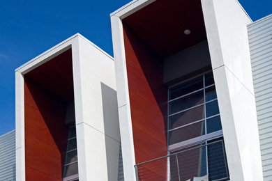 Modelo de fachada gris moderna de tamaño medio de tres plantas con revestimientos combinados