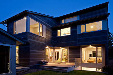 Diseño de fachada de casa marrón minimalista grande de dos plantas con revestimiento de madera, tejado a cuatro aguas y tejado de metal